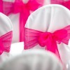 Wedding Chair Covers in white with pink bows.