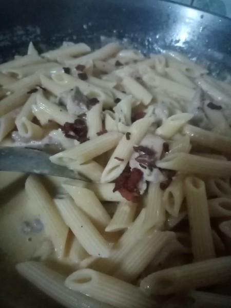 adding crispy bacon to penne