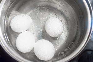 Eggs being hard boiled in water.