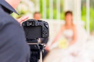 A photographer taking a picture of a wedding couple.