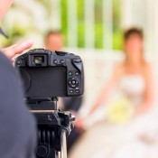 A photographer taking a picture of a wedding couple.