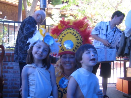 Two kids and a woman in Tahitian costumes.