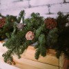 Branches trimmed off a Christmas tree are used to decorate a fireplace mantle or shelf.