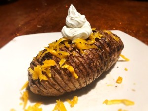 Crispy Cheesy Potato on plate with sour cream on top