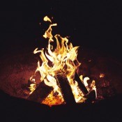 A campfire in a round firepit.