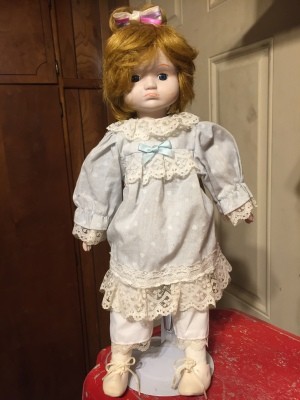 Value of a Heritage Porcelain Doll - red haired doll wearing a lace trimmed light blue dress and pantaloons