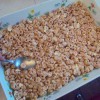 pressing Cheerio Peanut Butter treats into pan