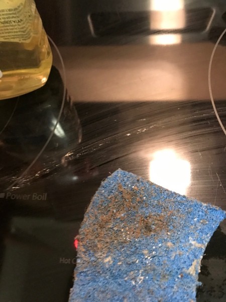 A scrubby pad with gunk cleaned from the hood.