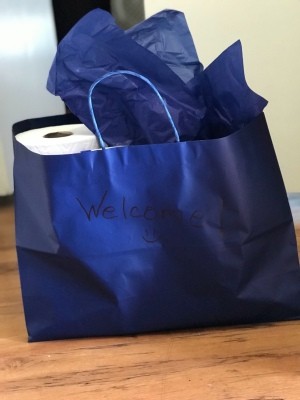 A gift bag filled with cleaning supplies as a welcome gift.