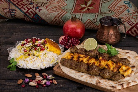 A selection of Persian (Iranian) foods next to a traditional rug.