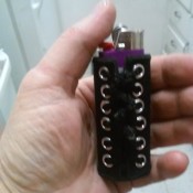 A lighter in a cover that is made with eyelets.