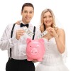 Bride and groom adding money into a piggy bank.