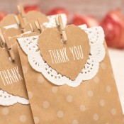 Wedding favors in brown paper bags embellished with paper doilies.