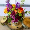 Centerpiece of Flowers in a watering can on rounds of wood