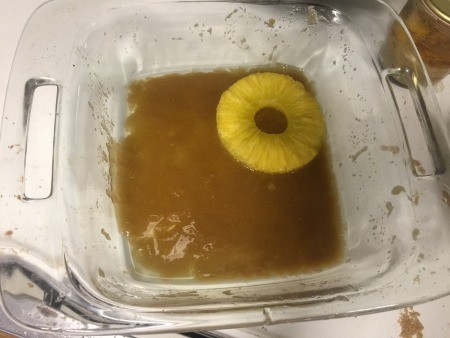 melted butter & sugar in baking dish with pineapple