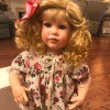 Value of a Danbury Mint Doll - blond child doll wearing a floral dress