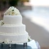 Three-tiered wedding cake with flowers on top.