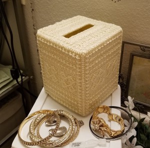 A yarn covered empty tissue holder.