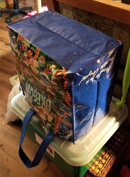 A shopping bag upended on a container to dry.