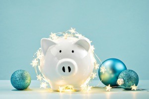 A piggy bank with Christmas lights and ornaments.