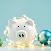 A piggy bank with Christmas lights and ornaments.