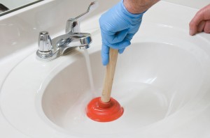 A plunger being used in a bathroom sink.