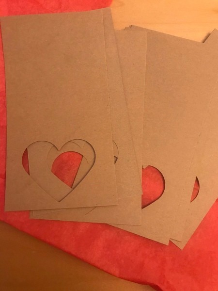 Simple Heart Garland - sheets with heart cutouts on top of red tissue paper