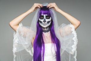 Halloween bride with purple hair and a painted face.