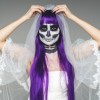 Halloween bride with purple hair and a painted face.