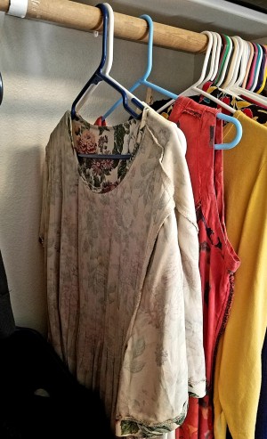 Clothing hung inside out in a closet, as a reminder that it needs to be mended.