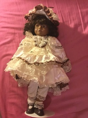 Identifying a Porcelain Doll - dark skinned doll wearing a lacy dress and hat