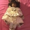Identifying a Porcelain Doll - dark skinned doll wearing a lacy dress and hat
