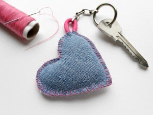 A denim heart with pink thread made into a keychain.