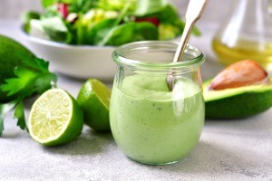 A small jar of green avocado mayonnaise.