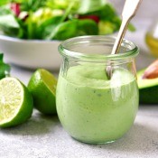 A small jar of green avocado mayonnaise.