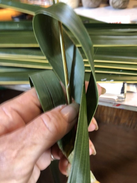Making Woven Coconut Leaf Shrimp - looping leaf from the right around the stem