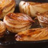 Baked onion halves on a sheet pan.
