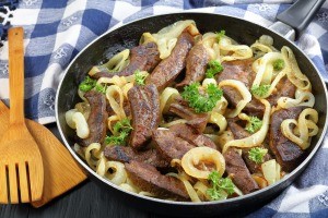 A frying pan filled with liver and onions.