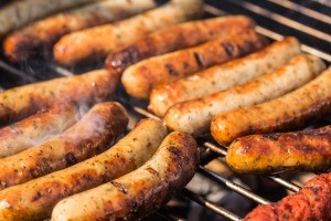 Bratwurst sausages on a grill.