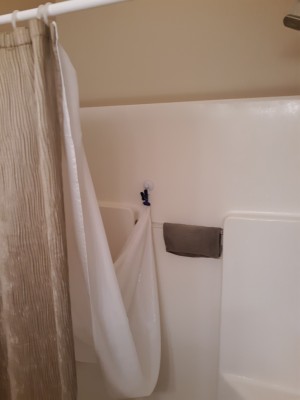 Prevent Mold and Mildew on Shower Curtain Liners - liner clipped to the side wall of the shower