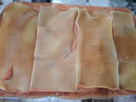 Lasagna noodles on sauce in pan