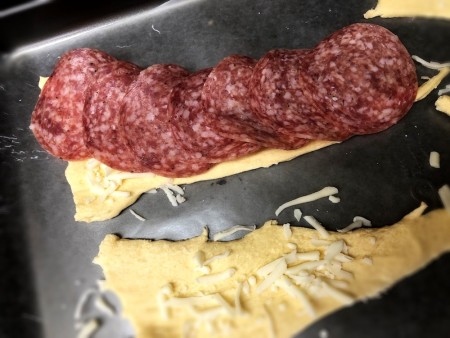 Salami & cheese laid on dough