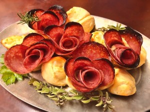 A plate of salami rose appetizers.