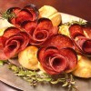 A plate of salami rose appetizers.