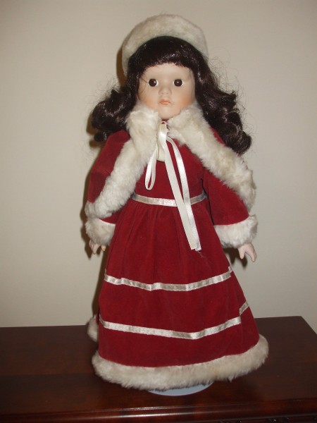 A collectible doll in a red and white Christmas outfit.