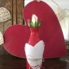 Transform any Vase into a One with a Valentine's Theme - red bottle with heart decoration with a rose bud,  in front of a red wood/paper heart