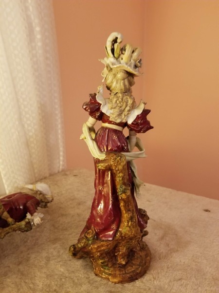A ceramic figurine of a woman in a fancy hat.