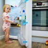 A toddler in an open refrigerator.