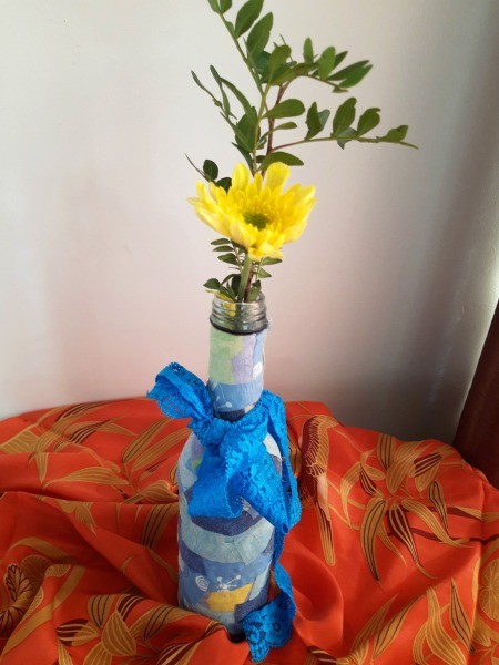 Fabric Covered Specimen or Bud Vase - greenery and a yellow flower in bottle with a blue ribbon tied to neck