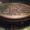 An intricately carved round wooden table.